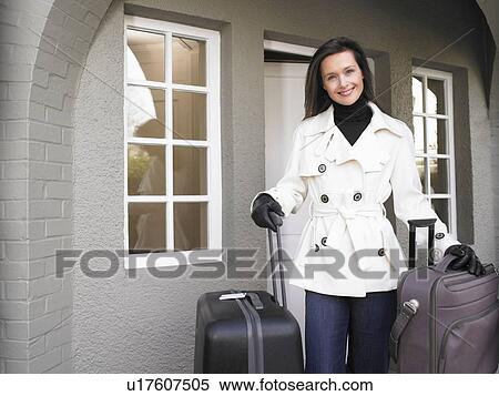Woman holding suitcases on the patio View Large Photo Image Stock Photography - Woman holding suitcases on the patio. Fotosearch