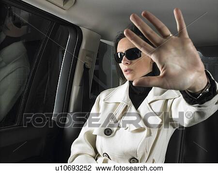 Stock Image - Woman in car, sunglasses on. Fotosearch