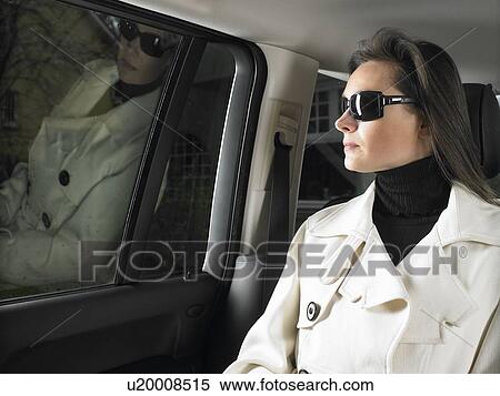 Stock Photography - Woman in car, sunglasses on. Fotosearch