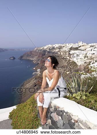Woman sitting on a low wall View Large Photo Image Stock Photography - Woman sitting on a low wall. Fotosearch