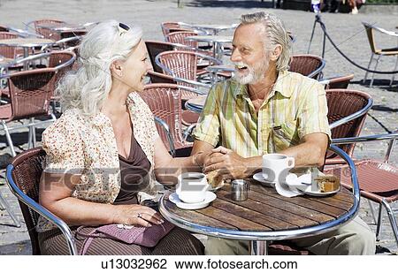 Couple holding hands by table View Large Photo Image Stock Image - Couple holding hands by table. Fotosearch