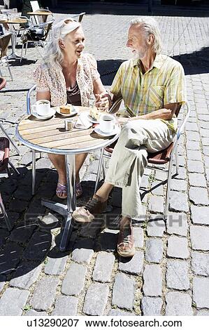 Couple sitting at caf? table View Large Photo Image Stock Photo - Couple sitting at caf? table. Fotosearch