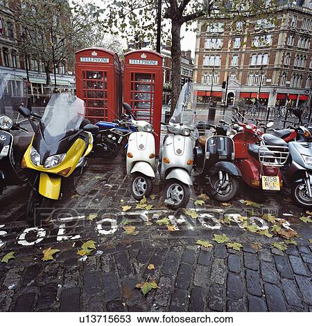 Parked motorbikes and scooters by phone booths in London. View Large Photo Image Stock Image - Parked motorbikes and scooters by phone booths in London.. Fotosearch