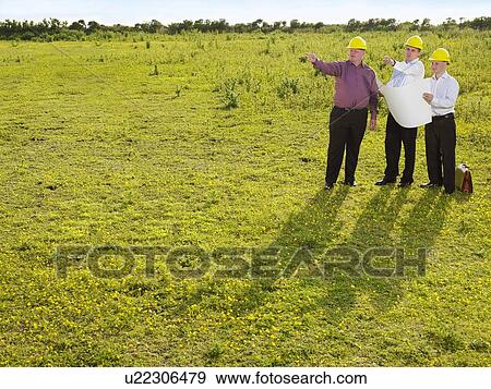 Stock Photo - Three surveyors on a field.. Fotosearch