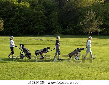 Picture - Three women on a golf fairway. Fotosearch