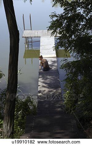 Woman sitting on pier. View Large Photo Image Stock Image - Woman sitting on pier.. Fotosearch