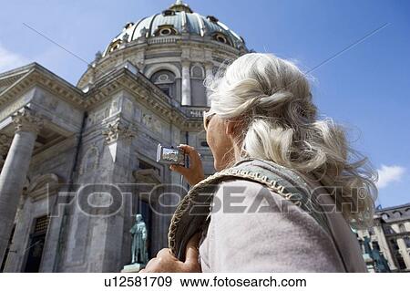 Woman taking picture of church View Large Photo Image Stock Photo - Woman taking picture of church. Fotosearch