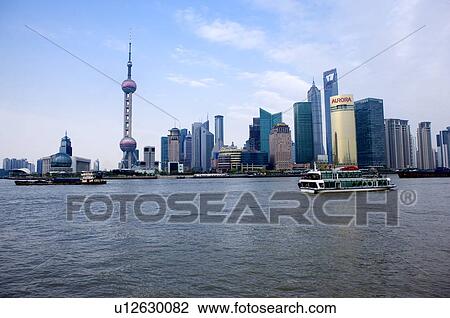 China, Shanghai, loose pulley traveling on Huangpu River with Pudong skyline in background View Large Photo Image Stock Image - China, Shanghai, loose pulley traveling on Huangpu River with Pudong skyline in background. Fotosearch