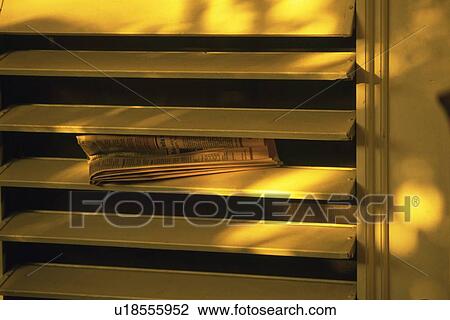 Stock Image - Newspaper Stuck in the Window Shade, Close Up. Fotosearch