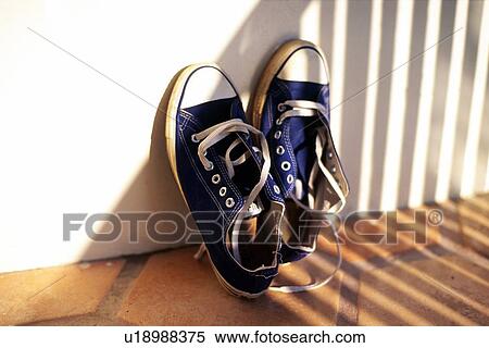 Stock Photography - Sneaker Leaning Against White Wall, Close Up. Fotosearch