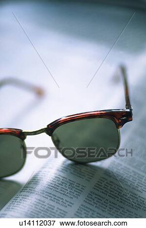 Stock Photo - Sunglass on Magazine, High Angle View, Close Up, Differential Focus. Fotosearch