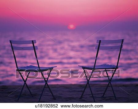 Stock Image - Two Chairs at Sunset Beach. Fotosearch