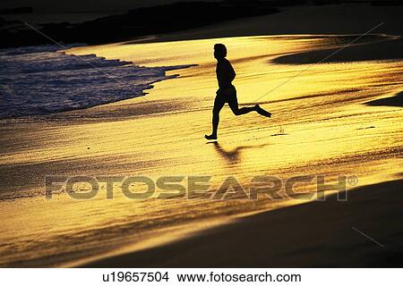 Picture - A Silhouette Man Running on the Evening Beach, Side View. Fotosearch