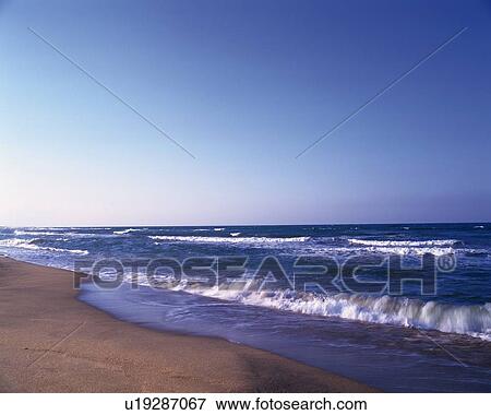 The Blue Sky and the Waves Lapping at the Sandy Beach View Large Photo Image Stock Photo - The Blue Sky and the Waves Lapping at the Sandy Beach. Fotosearch