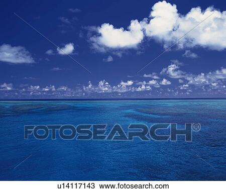 Stock Image - Tropical Ocean and the Clouds Sailing in the Blue Sky, Pan Focus. Fotosearch