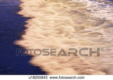 Stock Image - Waves Lapping at the Beach, Long Exposure. Fotosearch