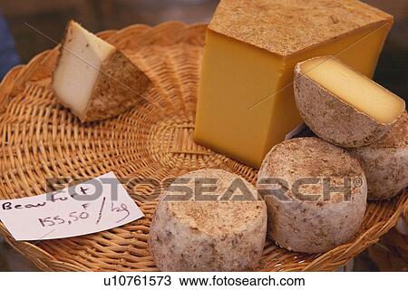 Stock Image - Closed Up Image of Several Different Cheese Sorts on a Wooden Plate, High Angle View, Paris, France. Fotosearch