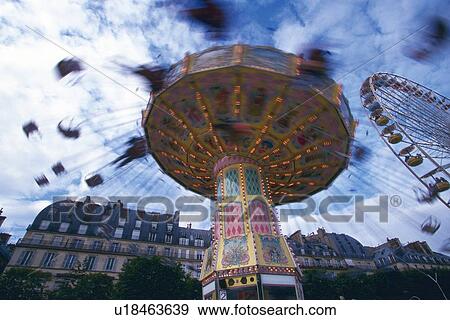 Stock Photo - Image of a Carousel in Motion Under a Cloudy Sky, Low Angle View, Blurred Motion, Paris, France. Fotosearch