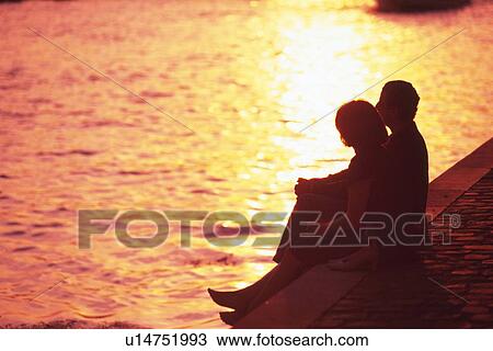 Stock Image - Image of a Couple Resting By the Seine, High Angle View, Side View, Paris, France. Fotosearch