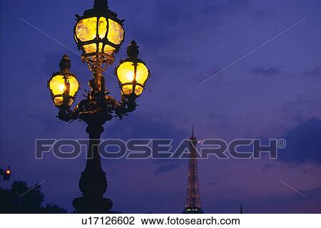 Stock Image - Image of a Decorative Streetlamp Under a Dark Blue Sky, Low Angle View, Paris, France. Fotosearch