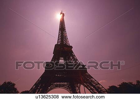 Stock Photo - Image of the Eiffel Tower By Sunset, the Sun Visible on the Top of the Tower, Low Angle View, Lens Flare, Paris, France. Fotosearch