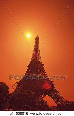 Stock Photograph - Image of the Eiffel Tower by Sunset, the Sky Red From the Color of the Sun, Low Angle View, Lens Flare, Paris, France. Fotosearch