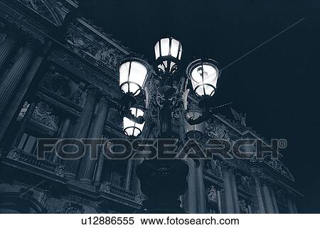 Stock Photography - Closed Up Image of a Shining Streetlamp In Front of a Parisian Apartment House, Low Angle View, Paris, France. Fotosearch