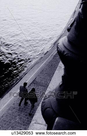 Image of a Couple Taking a Walk Along a River, High Angle View, Paris, France View Large Photo Image Stock Image - Image of a Couple Taking a Walk Along a River, High Angle View, Paris, France. Fotosearch