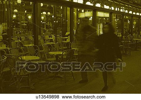 Stock Photo - Image of a Couple Walking By a Parisian Café, Side View, Blurred Motion, Paris, France. Fotosearch