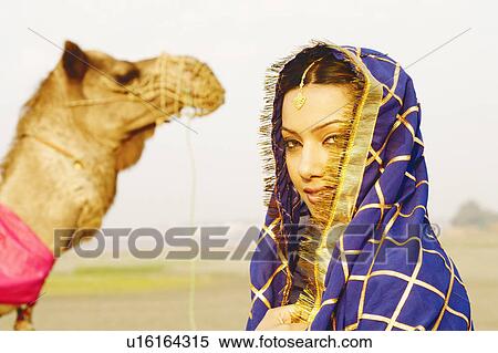 Close-up of a young woman with a camel in the background View Large Photo Image Stock Photography - Close-up of a young woman with a camel in the background. Fotosearch