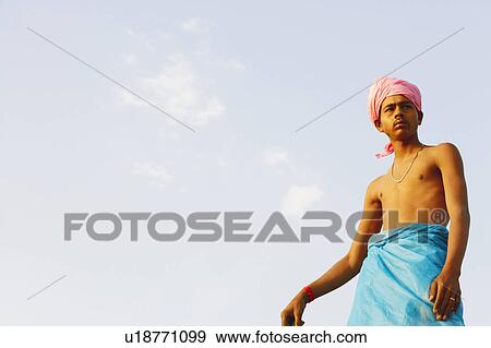 Low angle view of a young man looking sideways View Large Photo Image Stock Photo - Low angle view of a young man looking sideways. Fotosearch