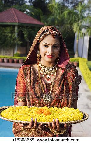 Portrait of a bride holding a tray of flower garlands in a traditional wedding dress View Large Photo Image Stock Photo - Portrait of a bride holding a tray of flower garlands in a traditional wedding dress . Fotosearch