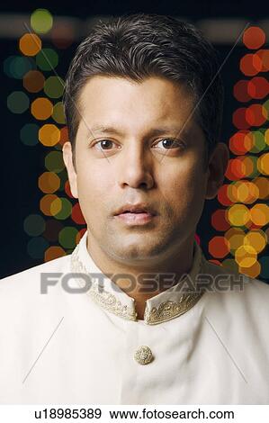 Stock Photo - Portrait of a mid adult man wearing traditional Indian clothing. Fotosearch