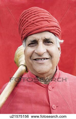 Stock Photograph - Portrait of a senior man carrying a weapon on his shoulder, Jaipur, Rajasthan, India. Fotosearch