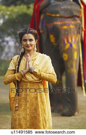 Portrait of a young woman greeting in front of an elephant View Large Photo Image Stock Photography - Portrait of a young woman greeting in front of an elephant. Fotosearch