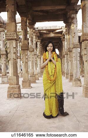 Portrait of a young woman standing in a prayer position wearing garlands View Large Photo Image Stock Photography - Portrait of a young woman standing in a prayer position wearing garlands. Fotosearch