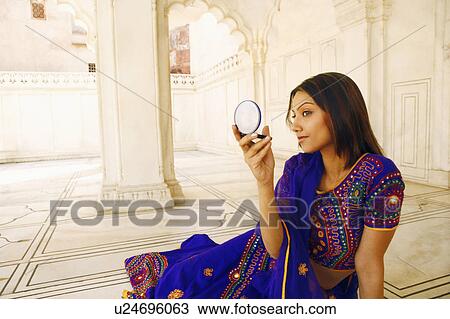 Close-up of a young woman holding a mirror View Large Photo Image Stock Image - Close-up of a young woman holding a mirror. Fotosearch