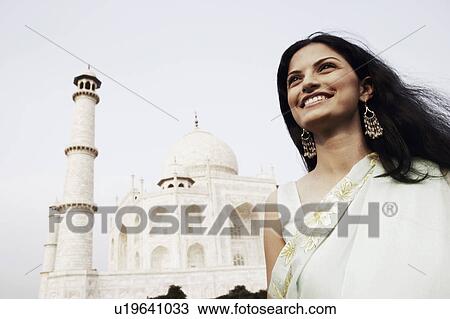 Close-up of a young woman standing in front of a mausoleum, Taj Mahal, Agra, Uttar Pradesh, India View Large Photo Image Stock Image - Close-up of a young woman standing in front of a mausoleum, Taj Mahal, Agra, Uttar Pradesh, India. Fotosearch