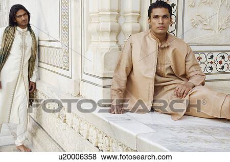 Stock Photo - Close-up of two young men leaning against a wall, Taj Mahal, Agra, Uttar Pradesh, India. Fotosearch