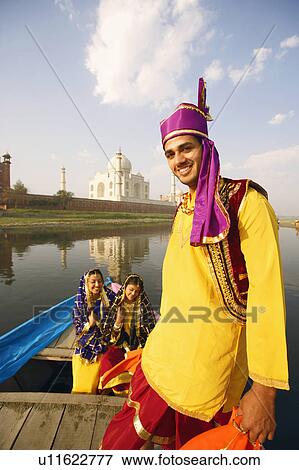 Portrait of a young man smiling with two young women sitting in a boat in the background, Taj Mahal, Agra, Uttar Pradesh, India View Large Photo Image Stock Photo - Portrait of a young man smiling with two young women sitting in a boat in the background, Taj Mahal, Agra, Uttar Pradesh, India. Fotosearch