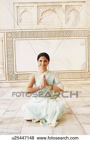 Stock Photo - Portrait of a young woman sitting in a prayer position in a mausoleum, Taj Mahal, Agra, Uttar Pradesh, India. Fotosearch