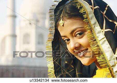 Portrait of a young woman smiling in front of a mausoleum, Taj Mahal, Agra, Uttar Pradesh, India View Large Photo Image Picture - Portrait of a young woman smiling in front of a mausoleum, Taj Mahal, Agra, Uttar Pradesh, India. Fotosearch