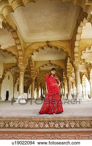 Portrait of a young woman standing with her hand on her hip, Agra Fort, Agra, Uttar Pradesh, India View Large Photo Image Picture - Portrait of a young woman standing with her hand on her hip, Agra Fort, Agra, Uttar Pradesh, India. Fotosearch