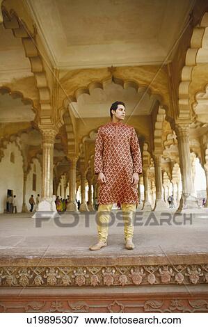 Low angle view of a young man standing and looking sideways, Agra Fort, Agra, Uttar Pradesh, India View Large Photo Image Stock Photo - Low angle view of a young man standing and looking sideways, Agra Fort, Agra, Uttar Pradesh, India. Fotosearch