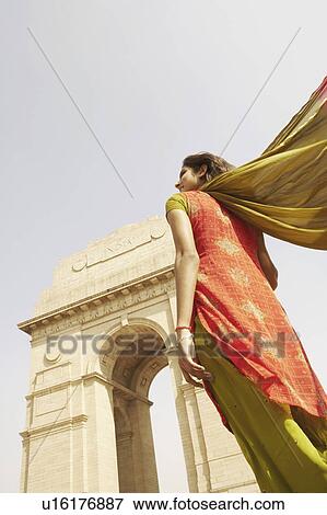 Low angle view of a young woman standing in front of a monument, India Gate, New Delhi, India View Large Photo Image Stock Photo - Low angle view of a young woman standing in front of a monument, India Gate, New Delhi, India. Fotosearch