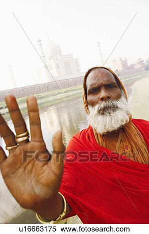 Stock Photography - Portrait of a priest making a stop gesture, Taj Mahal, Agra, Uttar Pradesh, India. Fotosearch