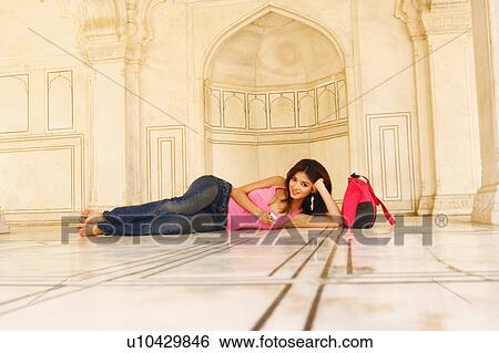 Portrait of a young woman lying on the floor View Large Photo Image Stock Photograph - Portrait of a young woman lying on the floor. Fotosearch