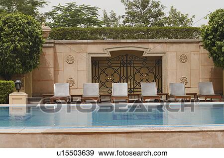 Stock Photo - Lounge chairs at the poolside. Fotosearch