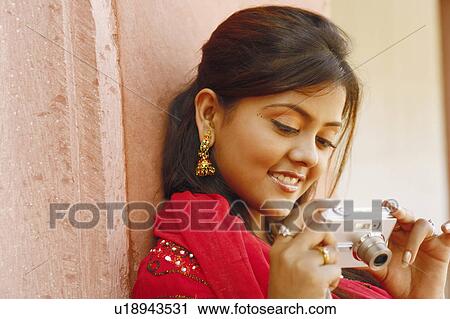 Close-up of a young woman looking at a digital camera, Agra Fort, Agra, Uttar Pradesh, India View Large Photo Image Stock Image - Close-up of a young woman looking at a digital camera, Agra Fort, Agra, Uttar Pradesh, India. Fotosearch