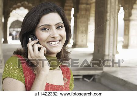 Stock Image - Portrait of a young woman talking on a mobile phone. Fotosearch